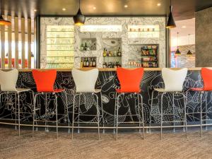 a bar with red chairs in a restaurant at Ibis Mexico Perinorte in Mexico City