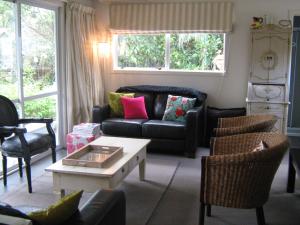a living room with a couch and chairs and a table at Number 10 - Kuratau in Kuratau