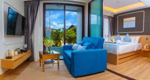 a bedroom with a blue chair and a bed at The Aristo Beach by Holy Cow, studio, without kitchen, mountain view in Surin Beach