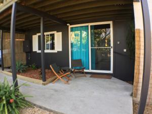 a screened in porch with two chairs and a table at High Tide at Emerald in Emerald Beach