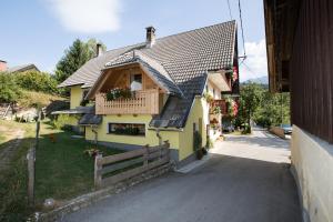 una casa gialla con portico e balcone di Farmhouse pri Miklavu a Bohinj