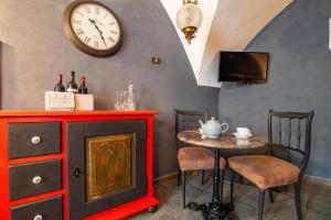 a dining room with a table and a clock on the wall at Portineria 26 in Martina Franca