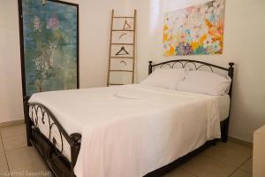 1 dormitorio con 1 cama con manta blanca en Beit Shapira, en Kefar Shammay