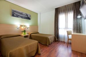 ein Hotelzimmer mit 2 Betten und einem Fenster in der Unterkunft 4C Bravo Murillo in Madrid