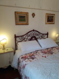 a bed in a bedroom with two lamps and two tables at Novecento B&B in Bollengo