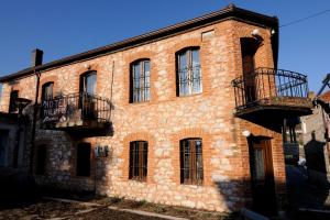 Psarádes的住宿－腓力酒店，一座古老的砖砌建筑,设有两个阳台