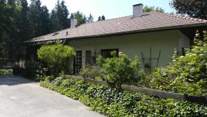une maison avec une clôture devant elle dans l'établissement Ferienhaus am Waldrand, à Ampflwang im Hausruckwald