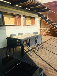 une terrasse en bois avec une table et des chaises. dans l'établissement Misericórdia Garden Homes, à Vila do Conde