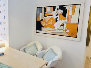 ア・コルーニャにあるEl loft de Santa Catalinaのテーブルと椅子2脚と絵画が備わる部屋