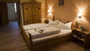 Schlafzimmer mit einem Bett mit weißer Bettwäsche und Kissen in der Unterkunft Hotel Restaurant Goger in Haßfurt
