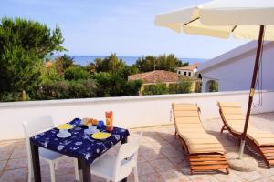 einen Tisch und Stühle auf einer Terrasse mit Sonnenschirm in der Unterkunft Hotel La Tartaruga Bianca in Valledoria