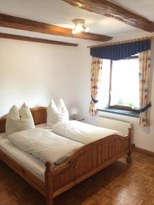 a bedroom with a wooden bed and a window at Gasthaus Hummel in Duggendorf