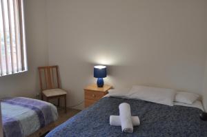 um quarto com 2 camas, uma cadeira e uma janela em Accommodation Sydney Kogarah 2 bedroom apartment with balcony em Sydney