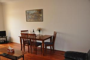 a dining room table and chairs in a living room at Accommodation Sydney Kogarah 2 bedroom apartment with balcony in Sydney