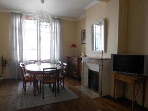 a living room with a dining room table and a television at 8 Rue de la Petite Bilange " Maison du Centre" in Saumur