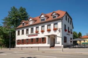 a white building with a red roof on a street at Hotel Restaurant de l'Europe in Wissembourg