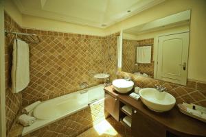 a bathroom with two sinks and a tub at Vila Alba Resort in Carvoeiro