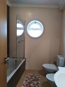 ein Badezimmer mit Toilette und Waschbecken und einem Fenster in der Unterkunft Casa dos avós in Alvor + 28 Fotos