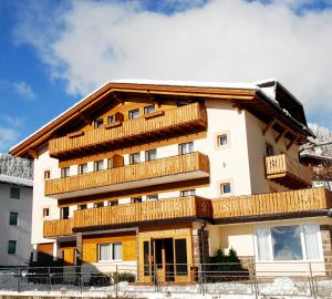 a building with wooden balconies on it at Residence Adler in San Martino di Castrozza