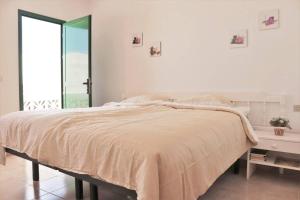 Un dormitorio blanco con una cama grande y una ventana en Oasis Atlántico: rincón secreto al pie de los senderos, en Azano