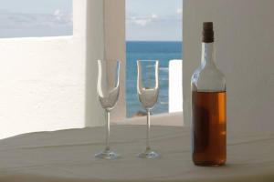 two wine glasses and a bottle on a table at Oasis Atlántico: rincón secreto al pie de los senderos in Azano
