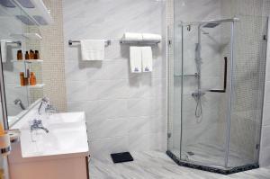 a bathroom with a shower and a sink at Parliament Palace Hotel in Khujand