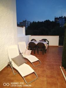 un grupo de sillas y mesas en un balcón en En el centro de Figueres 4 habitaciones 3 baños y 2 terrazas enormes, en Figueres