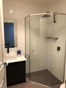 a bathroom with a glass shower and a sink at Port Boutique Accommodation in Port Fairy