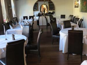 a dining room with white tables and black chairs at Gasthof Einhaus in Borken