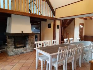 a dining room with a table and chairs and a fireplace at La Cantraigne in Audembert