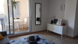 a living room with a tv and a mirror at Sète&Toi in Sète