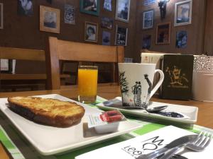 un plato con un trozo de pastel y una taza de zumo de naranja en El Trasgu de Foncebadón, en Foncebadón