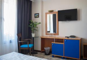 een hotelkamer met een bureau en een tv aan de muur bij Victoria Hotel Nessebar in Nesebar