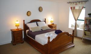 a bedroom with a wooden bed and two night stands at Ti Ar Bugale in Huelgoat