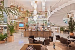 a lobby with tables and chairs and a bar at Meliá Palma Marina in Palma de Mallorca