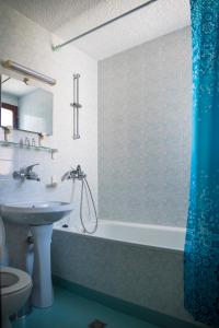 La salle de bains est pourvue d'une baignoire, d'un lavabo et de toilettes. dans l'établissement Victoria Hotel Nessebar, à Nessebar