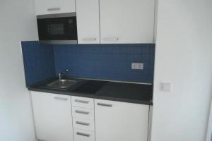 a small kitchen with a sink and a microwave at Messeappartement Unterrath in Düsseldorf