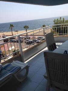 a balcony with a chair and a view of the beach at Residencial Aguilas Playa in Águilas