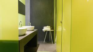 La salle de bains est pourvue de 2 lavabos et d'un comptoir avec des serviettes. dans l'établissement 101 Adrianou Apartments, à Athènes
