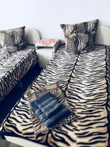 a couch with a zebra print blanket on it at Hotel - Hostel Marichka in Khmil'nyk