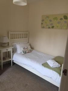 um quarto com uma cama branca com uma mesa de cabeceira e uma cama sidx sidx sidx em Upper Bray Cottage Badby, Daventry em Badby