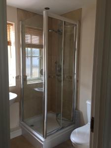 a glass shower in a bathroom with a toilet at Upper Bray Cottage Badby, Daventry in Badby