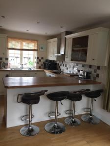 a kitchen with a counter with bar stools at Upper Bray Cottage Badby, Daventry in Badby