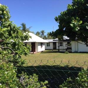 une maison avec une clôture devant elle dans l'établissement Chez Taia et Véro, à Tiputa