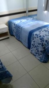 a bedroom with a bed with blue and white sheets at ÁGUAS DA SERRA- Rio Quente-GO APTO 2 Qtos particular- in Rio Quente
