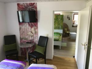 a room with two chairs and a table and a television on the wall at Anita's Zimmer in Engelhartszell