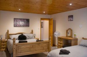 a cat sitting on a bed in a bedroom at Hilltop Cottage/ Penrhiw in Maentwrog