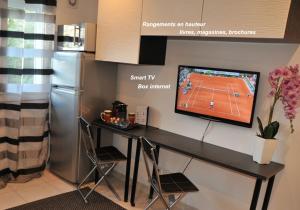cocina con mesa y TV en la pared en Studio Cannes Croisette Martinez, en Cannes