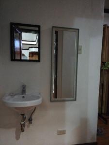 a bathroom with a sink and a mirror on the wall at Moalboal Guesthouse in Moalboal