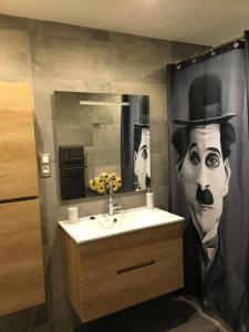 a bathroom with a painting of a man in a top hat at Studio 33 in Nice